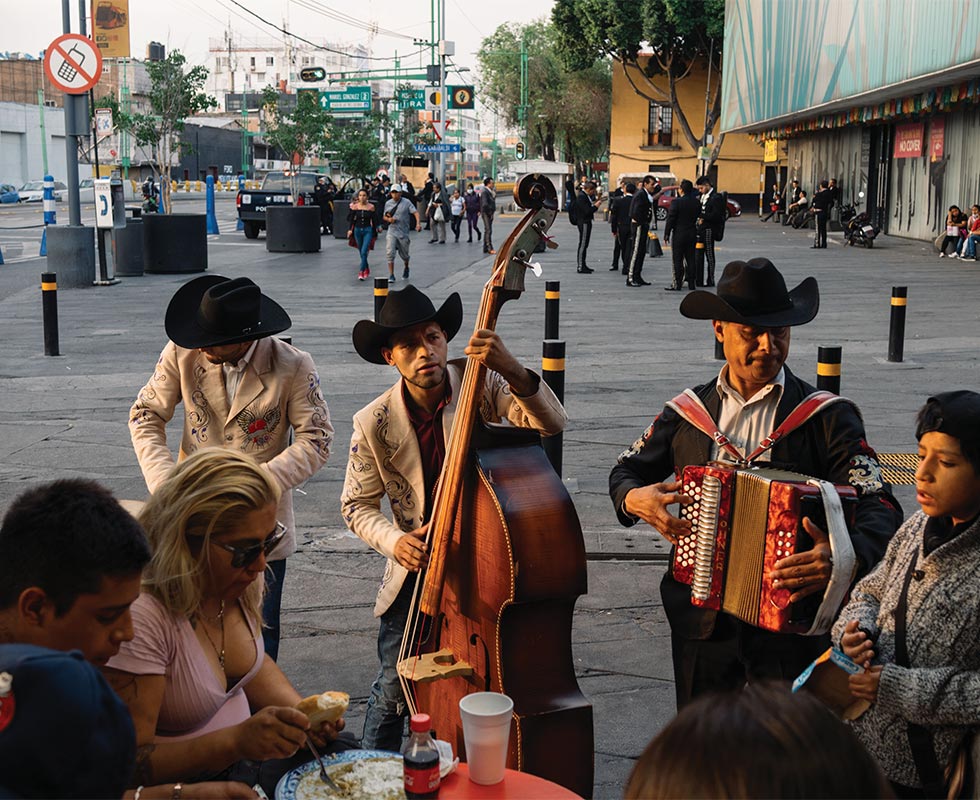 At the only restaurant open in Plaza Garibaldi, a family eats dinner while listening to a mariachi band play.