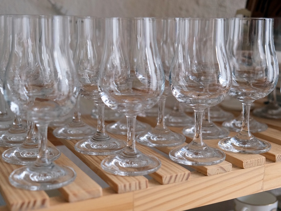 Wine glasses lined up neatly on a shelf.