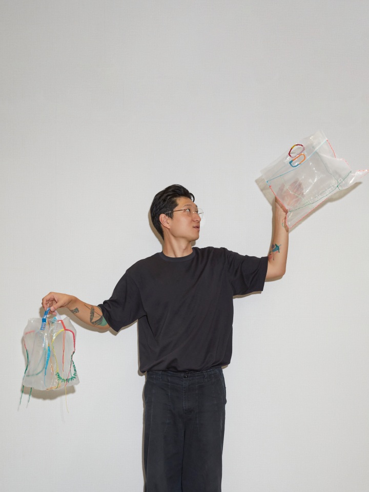 Hangun standing while holding a piece of work